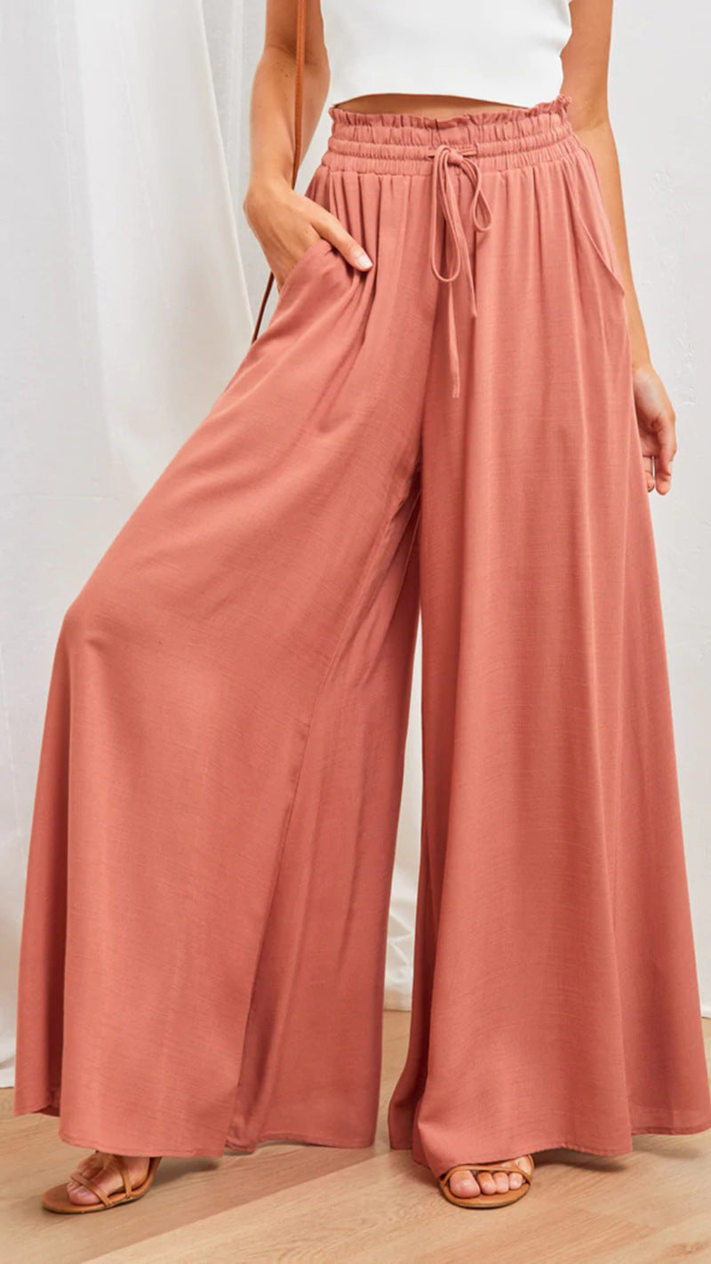 Person wearing pink wide-leg pants with a white background