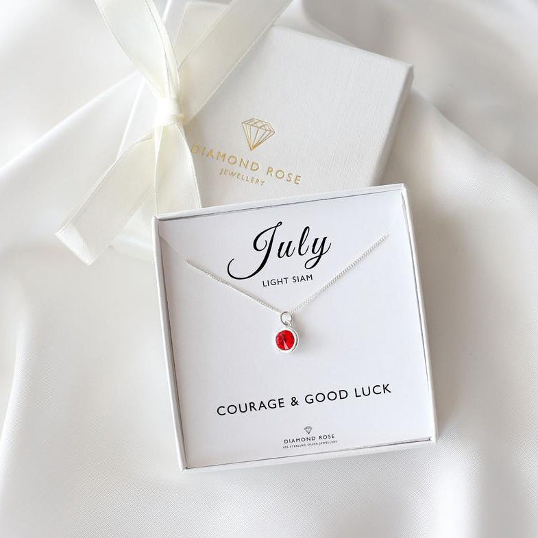 Diamond Rose jewelry box with a necklace featuring a red gemstone on a white background