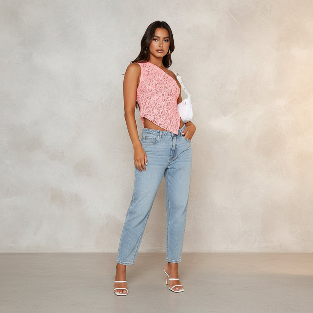 Woman wearing a pink lace halter top and blue jeans on a white background
