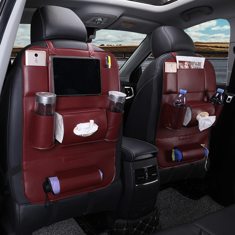 Car interior with red seat covers and various items on the backrests.