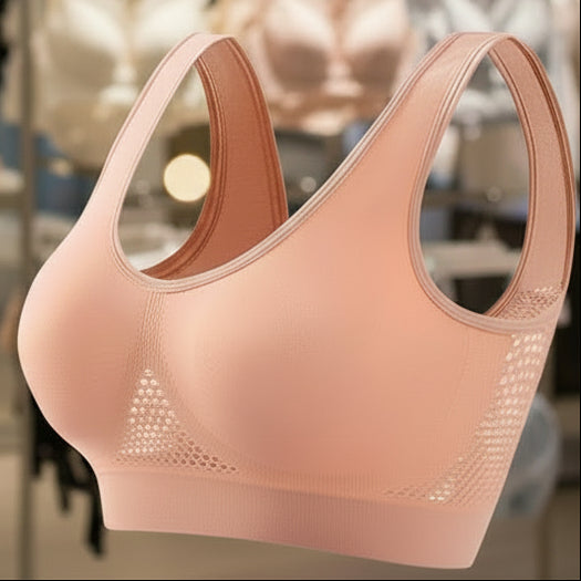Pink sports bra with mesh panels on a white background