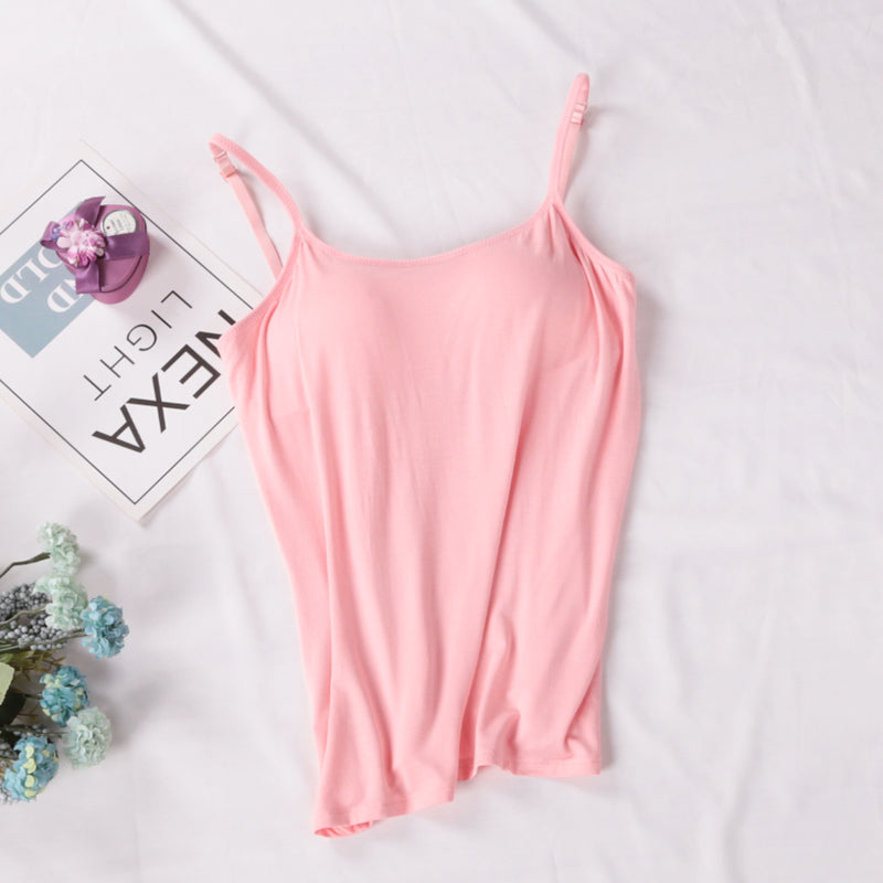Pink slip dress on a white surface with decorative elements.
