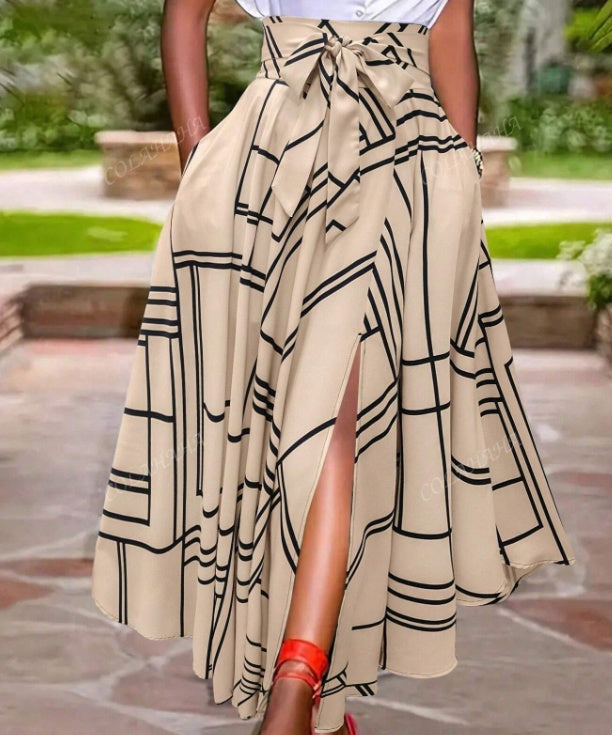 Person wearing a beige skirt with black geometric patterns outdoors.