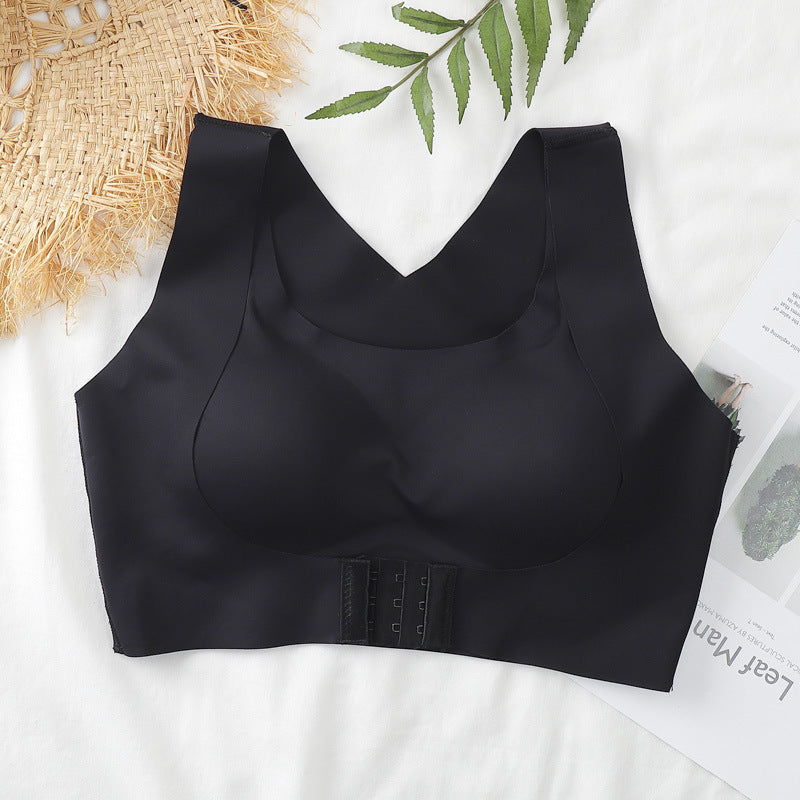 Black sports bra on a white surface with a plant leaf and newspaper in the background
