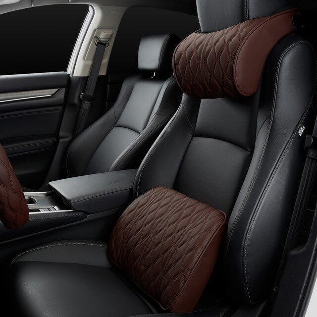 Car interior with black leather seats and brown headrest covers.