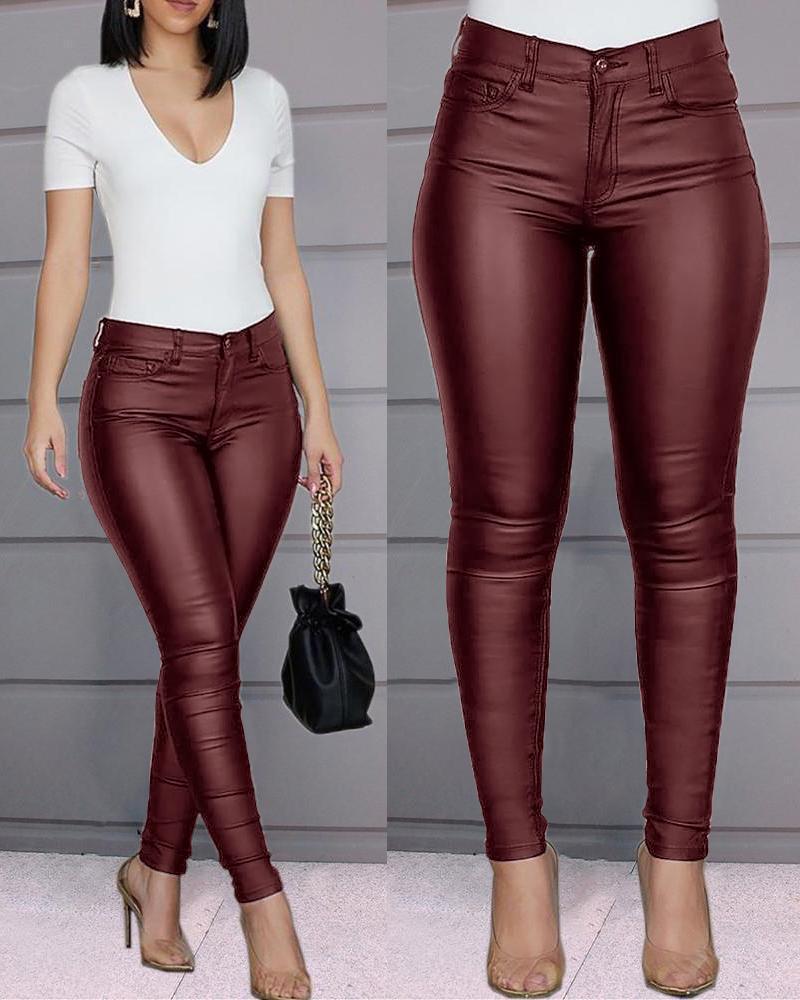 Maroon leather pants worn by a model with a plain background