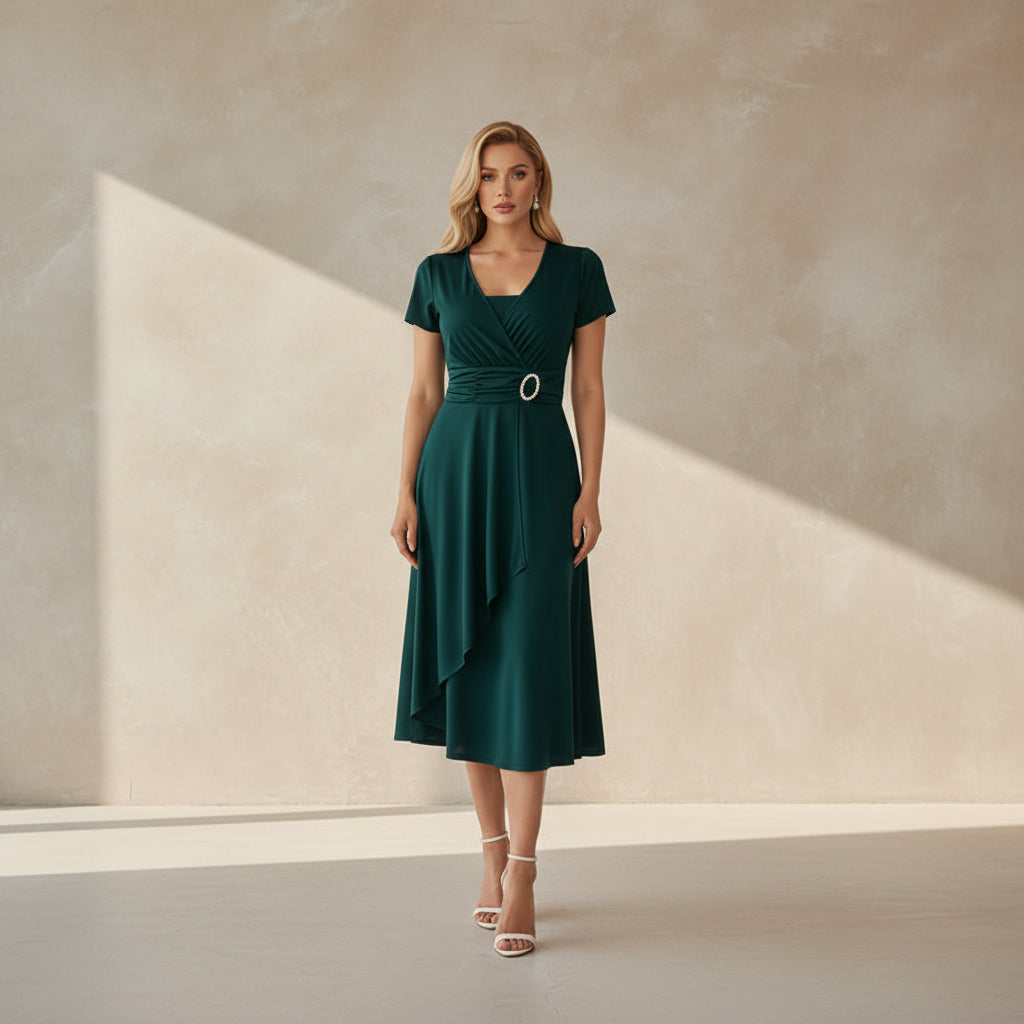 Woman wearing a green dress with a belt against a white background
