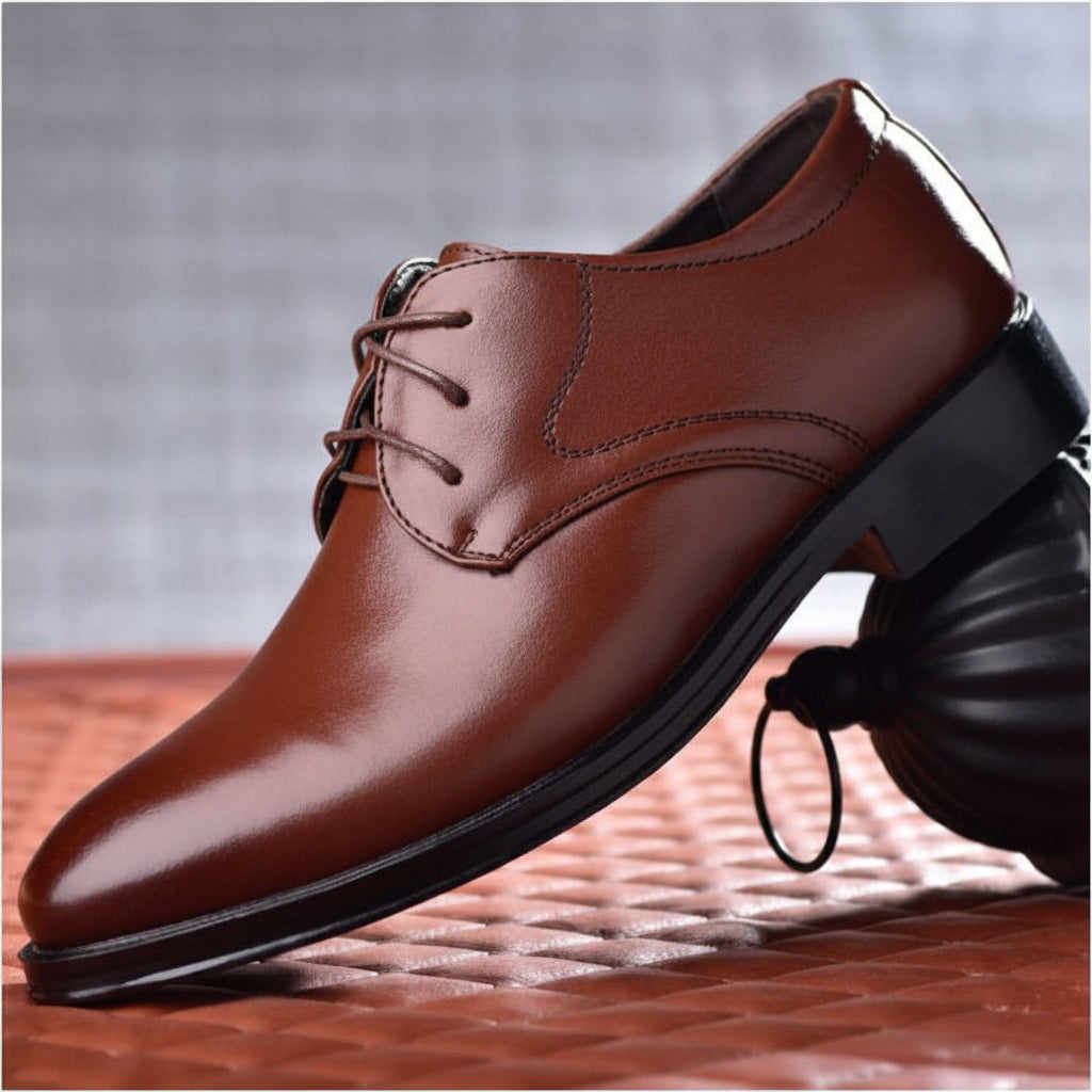 Brown leather dress shoe on a textured surface