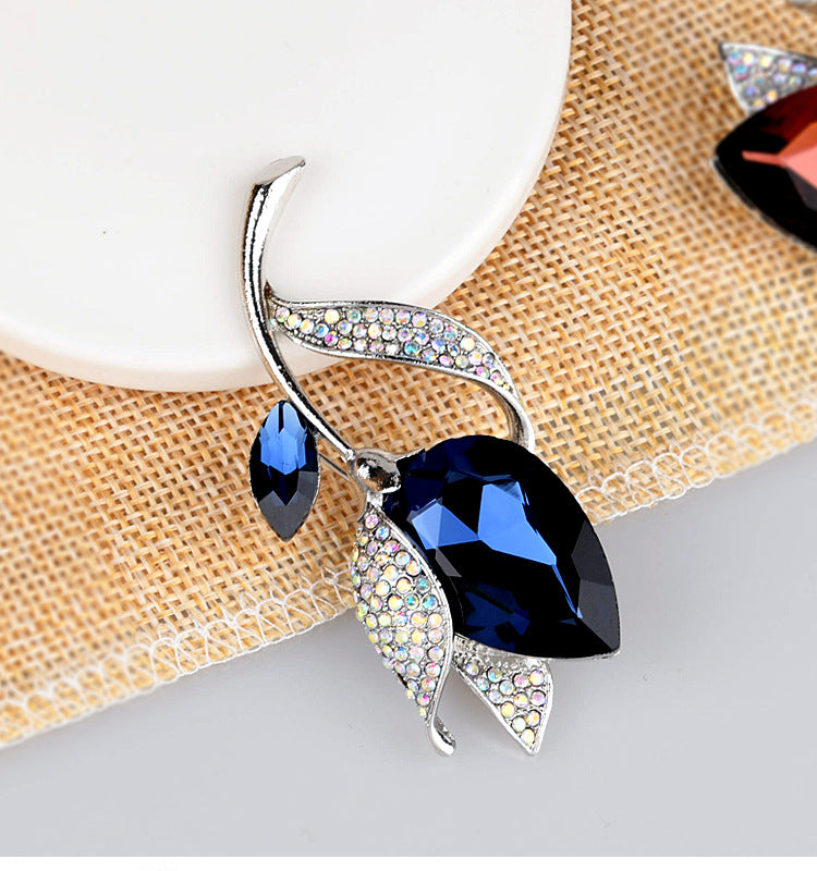Jewelry with blue gemstones and silver leaves on a textured surface