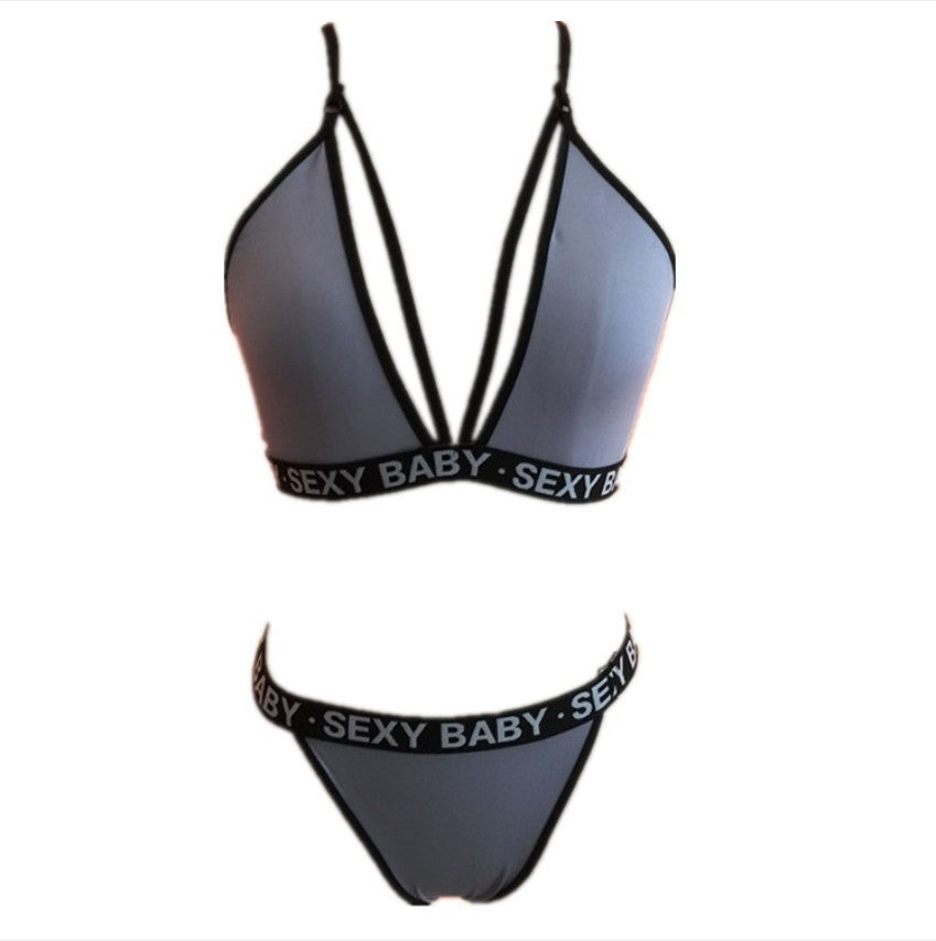 Black bikini set with 'SEXY BABY' waistband on a white background
