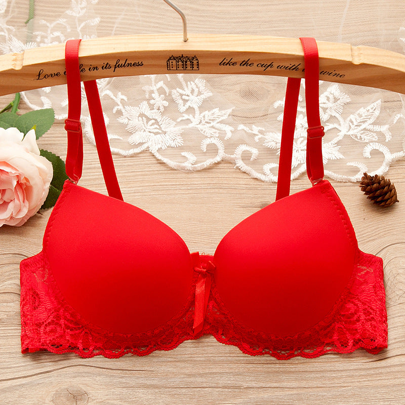 Red bra on a wooden hanger with floral and decorative elements in the background