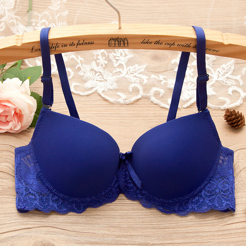 Blue bra on a wooden hanger with lace details on a wooden surface.