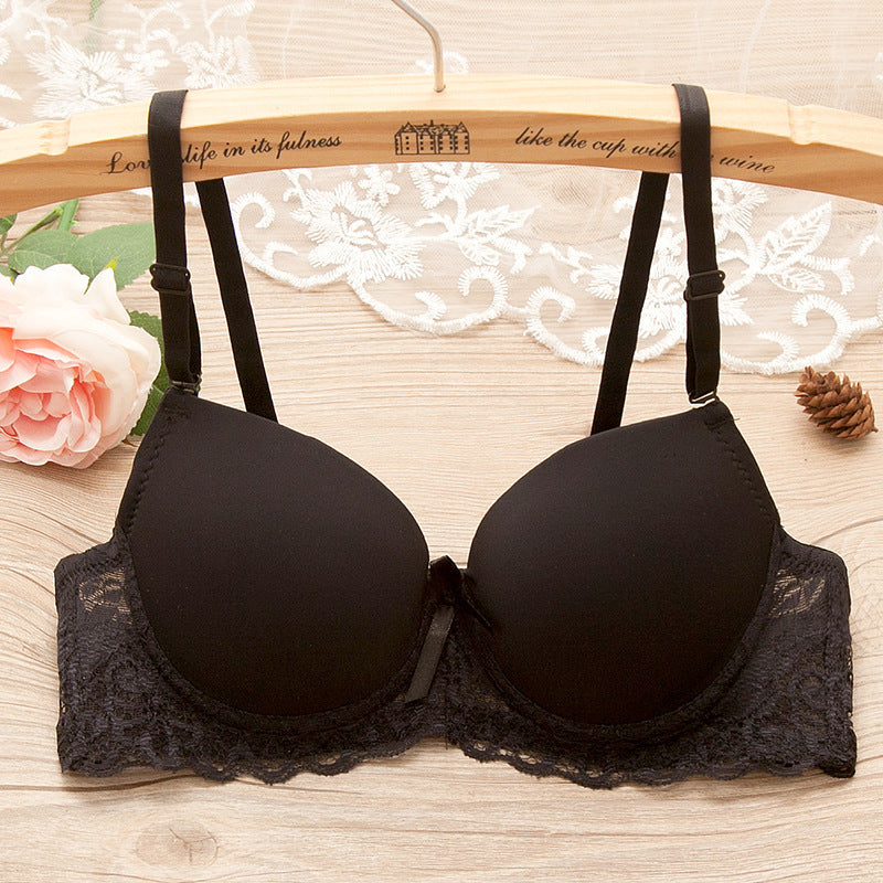 Black bra with lace trim on a wooden hanger with floral and decorative background