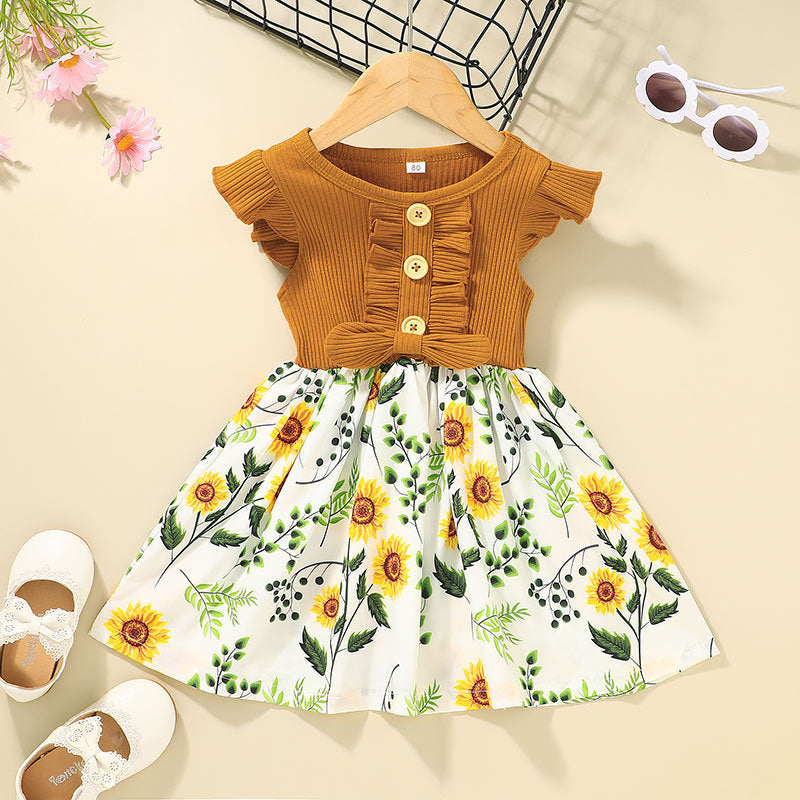 Children's outfit with mustard top and sunflower print skirt on a beige background