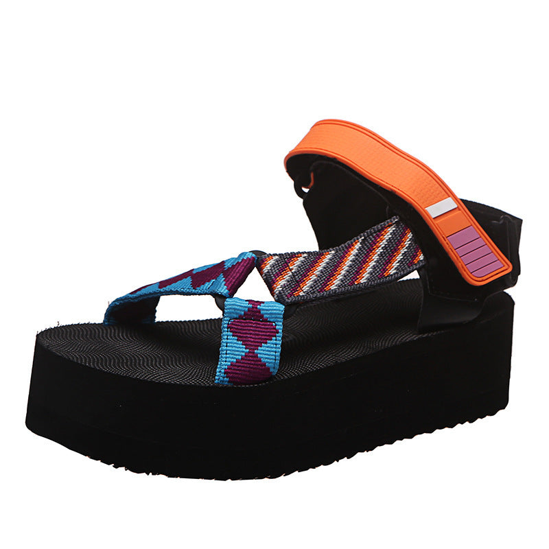 Black sandal with colorful strap and orange arch support on a white background