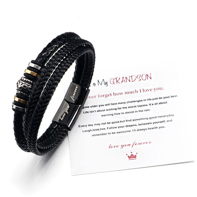 Black braided bracelet with metal accents on a white card with text and logo.