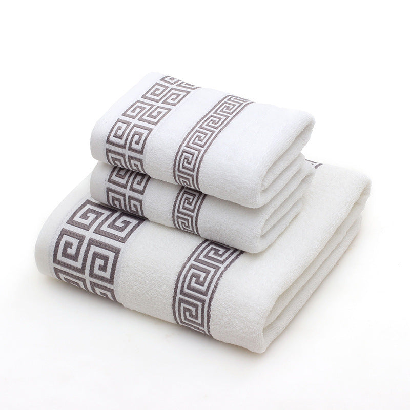 Set of three white towels with gray geometric patterns on a white background