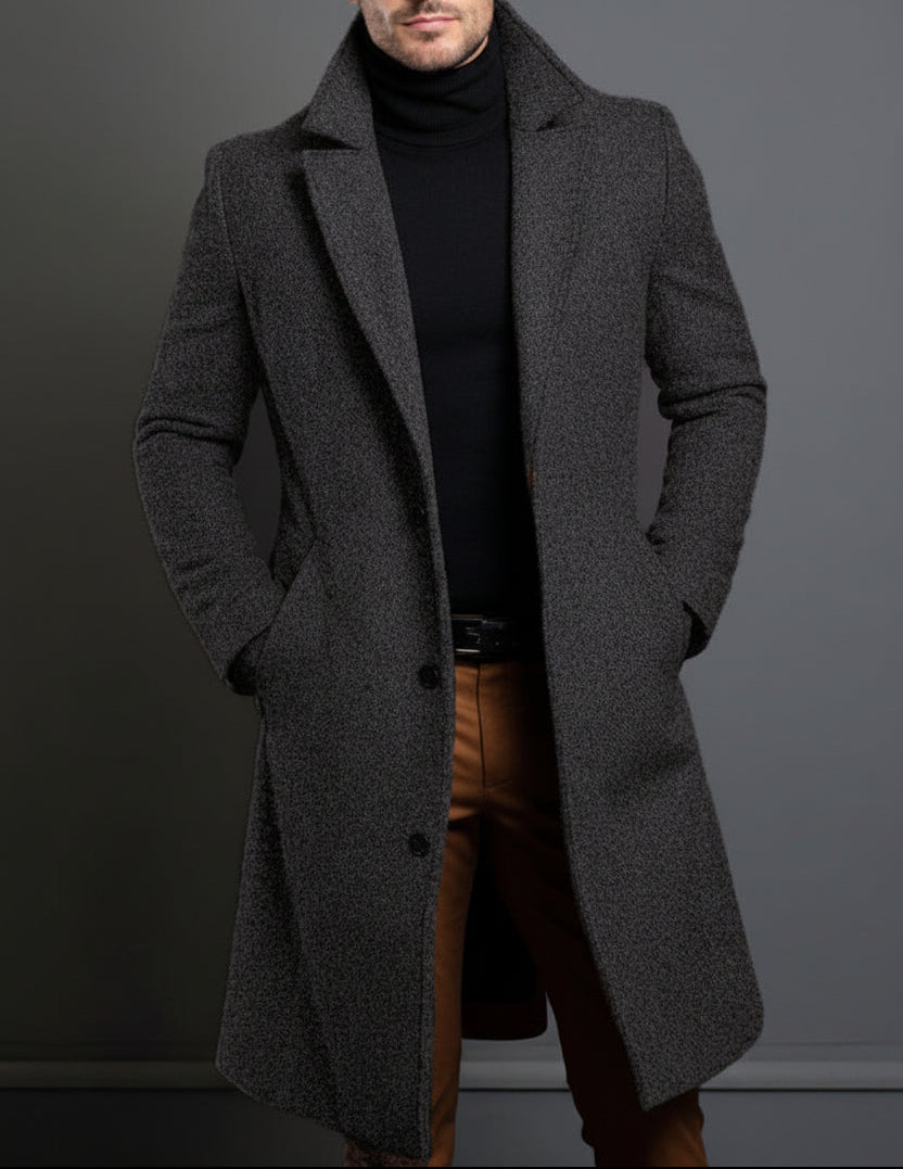 Man wearing a gray overcoat against a dark background