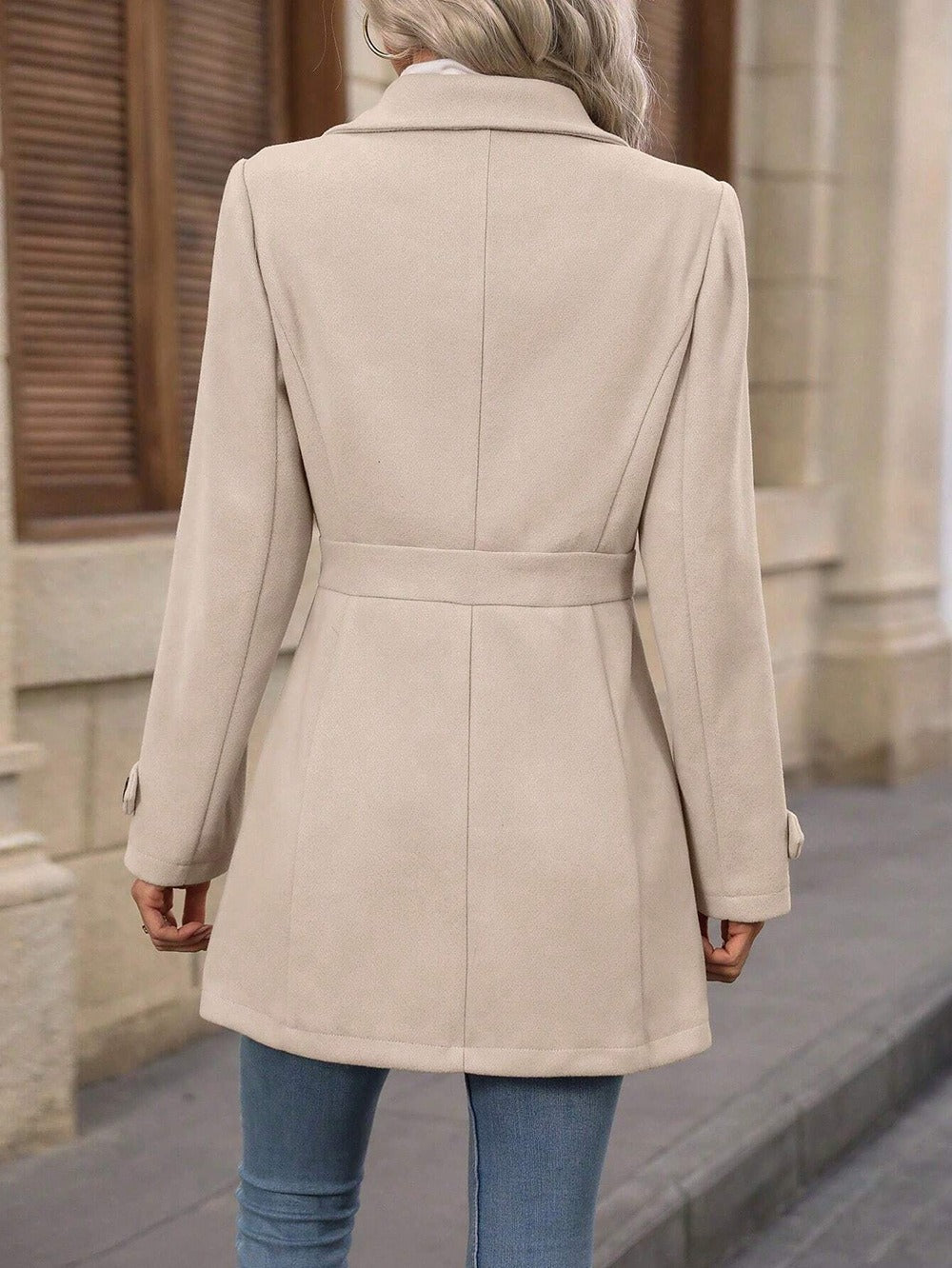 Person wearing a beige coat with a blurred background