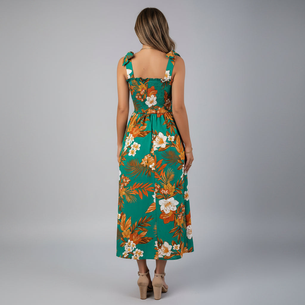 Woman wearing a floral dress in a room with a white wall and a plant.