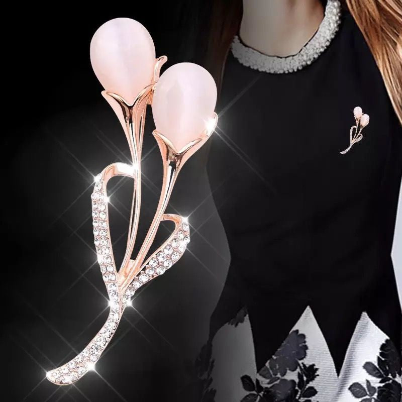Pink floral brooch with rhinestones on a black background