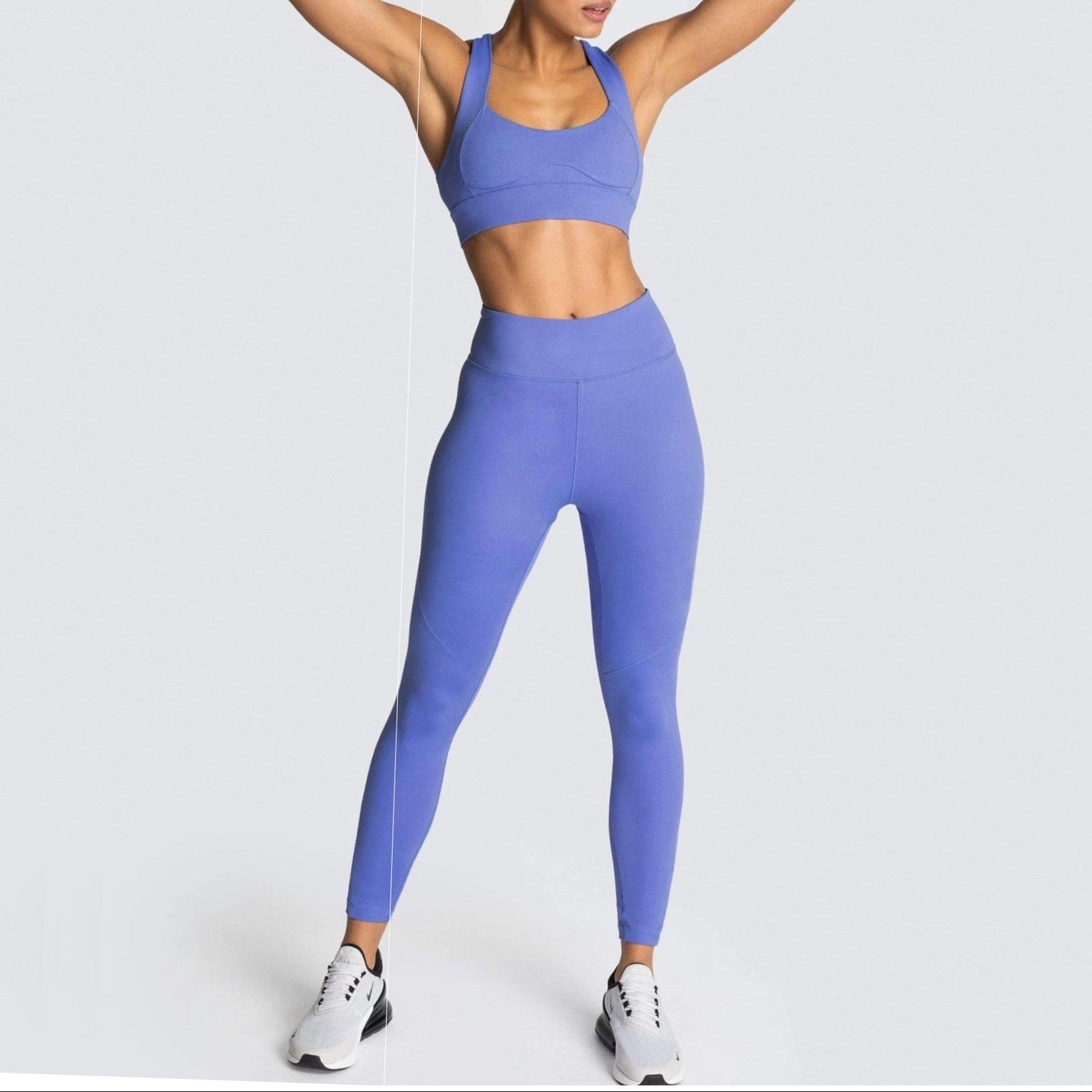 Woman wearing a blue athletic outfit on a light gray background
