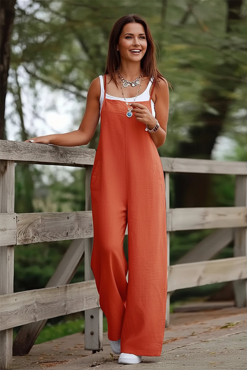 Person wearing an orange jumper standing near a wooden fence outdoors