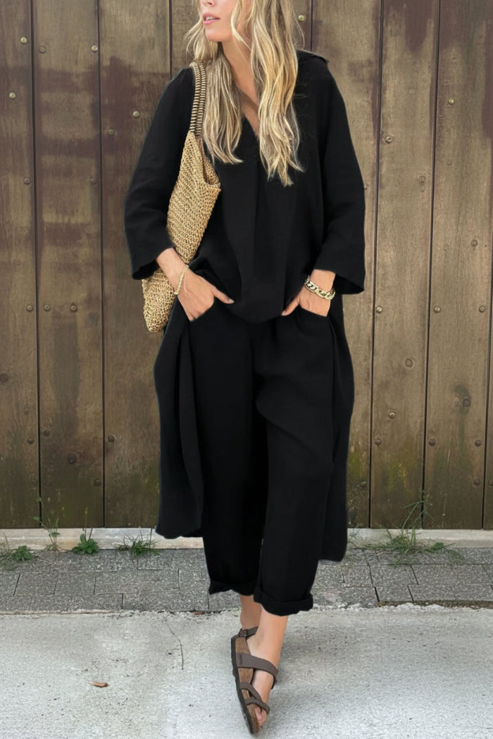 Person wearing a black outfit with a textured bag against a wooden background