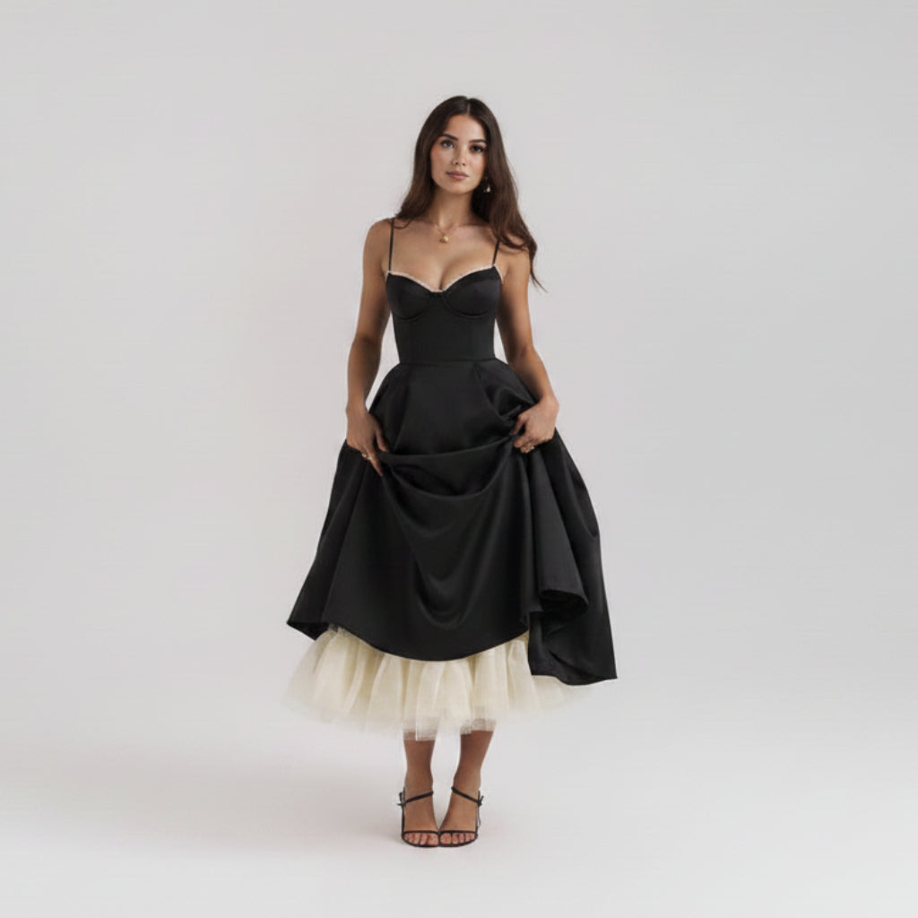 Black evening gown with a white tulle skirt on a plain background