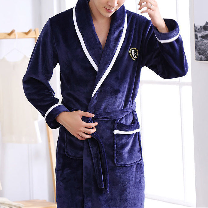Person wearing a navy blue robe with white trim in a room setting.
