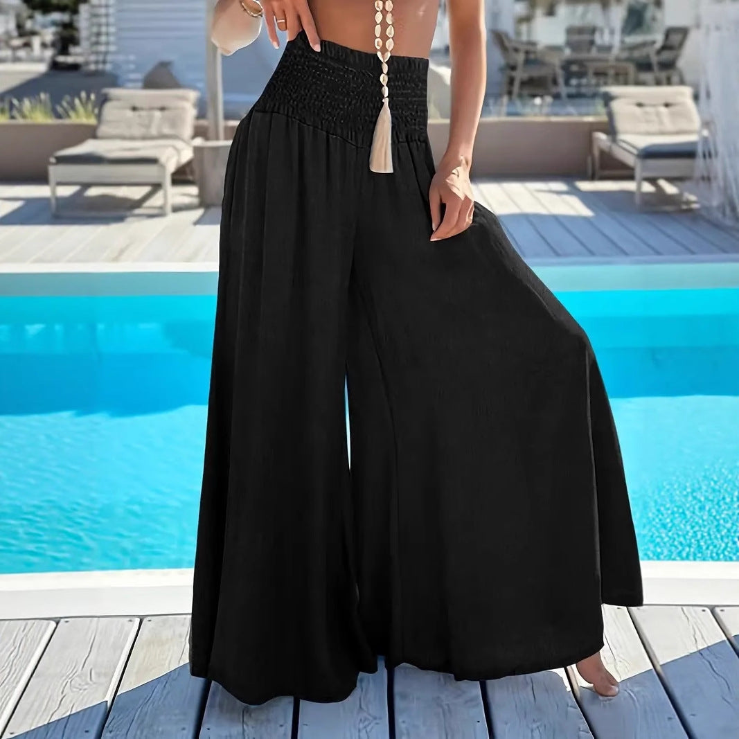 Person wearing black wide-leg pants by a poolside