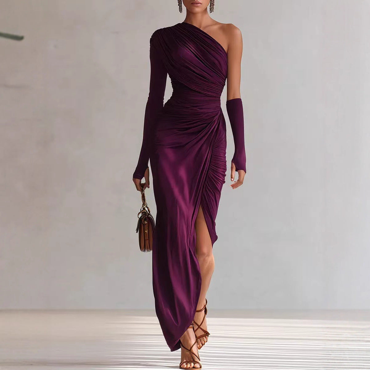 Woman wearing a purple one-shoulder dress with a slit, holding a brown handbag against a neutral background.