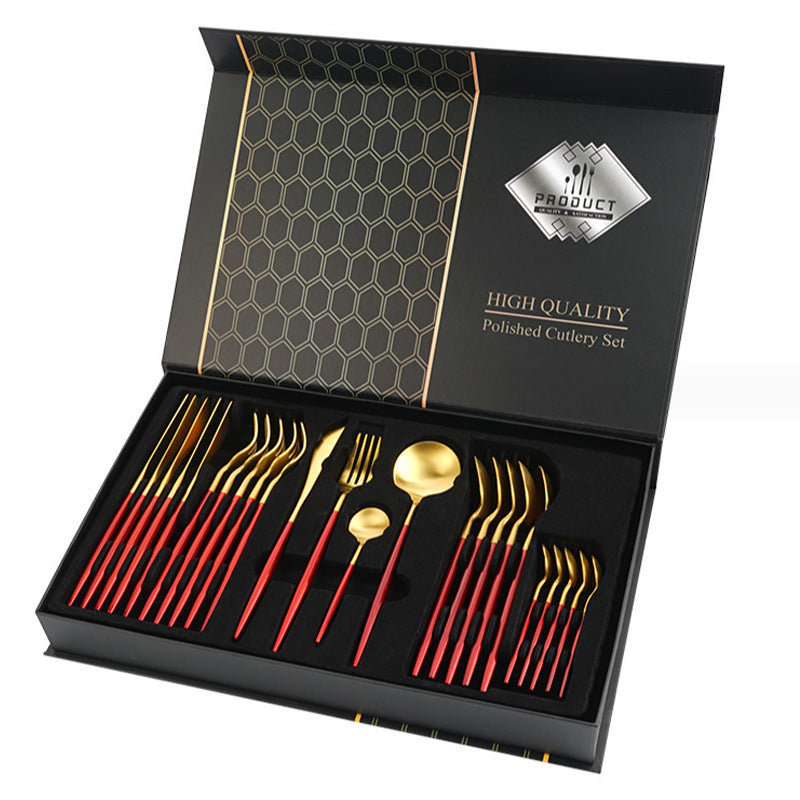 High-quality polished cutlery set with red handles in a black box packaging.