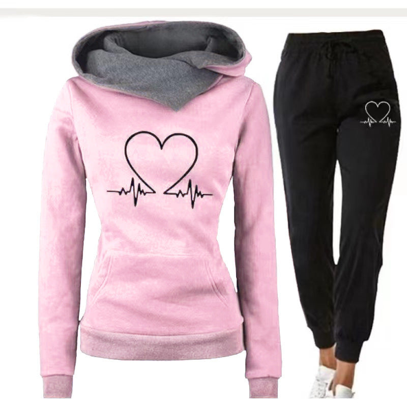 Pink hoodie with heart design and black pants with heart graphic on a white background
