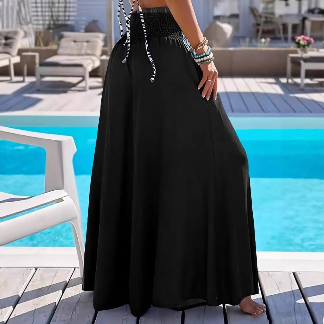 Person wearing a black dress by a poolside