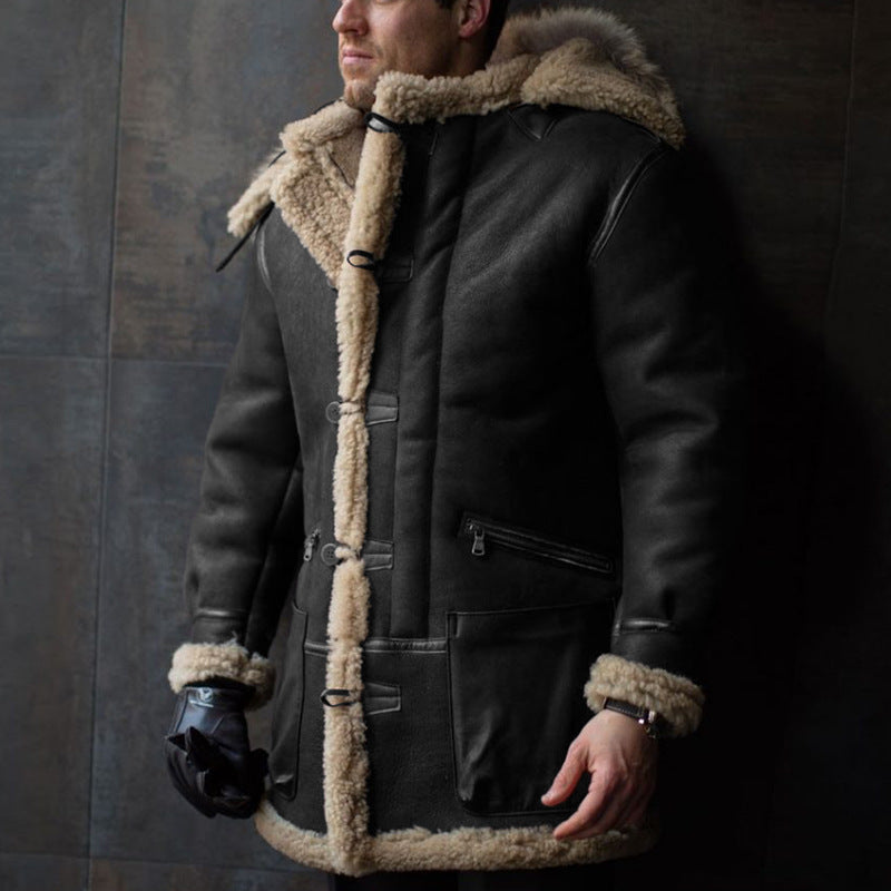 Man wearing a dark coat with fur trim against a dark background