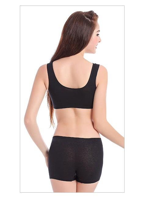 Woman wearing a black sports bra and shorts set on a white background