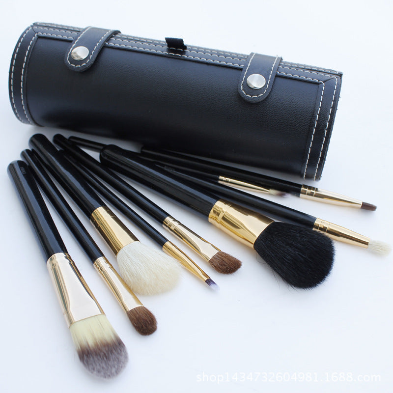 Set of makeup brushes with black and gold handles on a white background