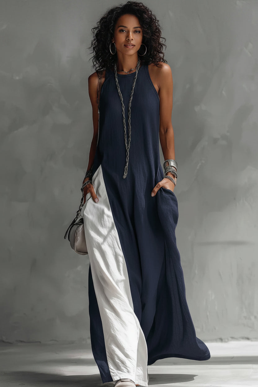 Woman wearing a long, dark blue and white dress against a gray background