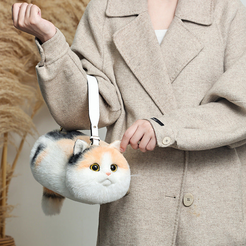 Person holding a fluffy cat-shaped bag with a neutral background