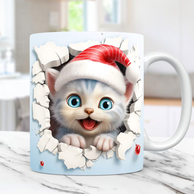 Mug with a design of a kitten wearing a Santa hat breaking through a wall.