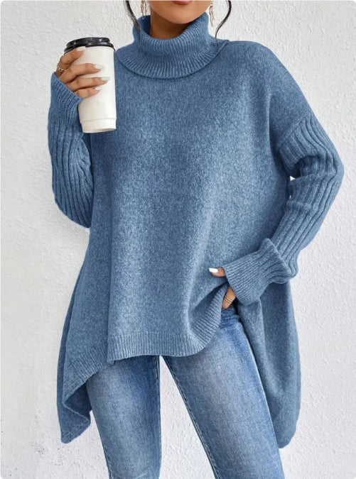 Person wearing a blue sweater and jeans holding a coffee cup against a white background