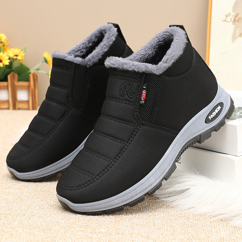 Black winter boots with gray lining on a beige surface