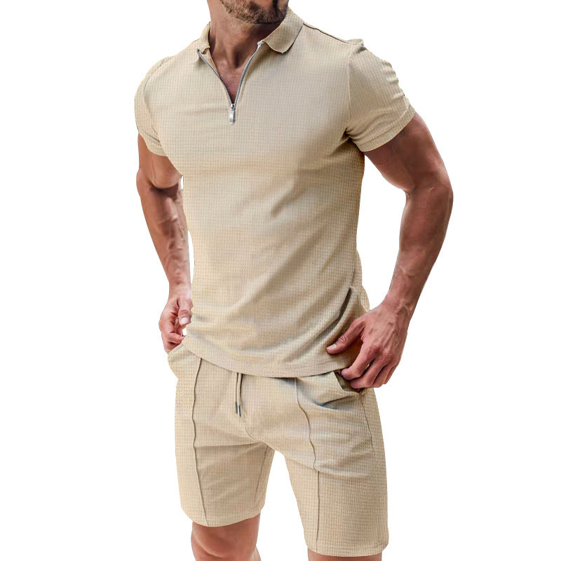 Man wearing a beige checkered polo shirt and shorts on a white background