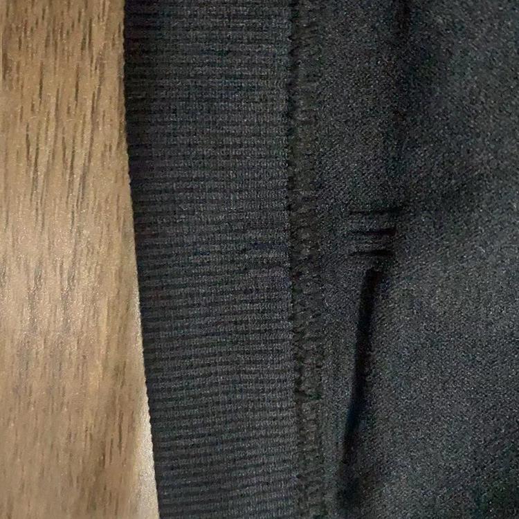 Close-up of a textured dark gray fabric on a wooden surface