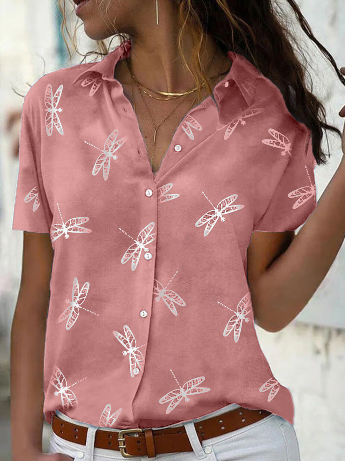 Person wearing a pink shirt with white dragonfly patterns