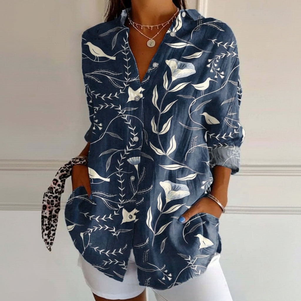 Navy blue shirt with white floral and bird pattern worn by a person.