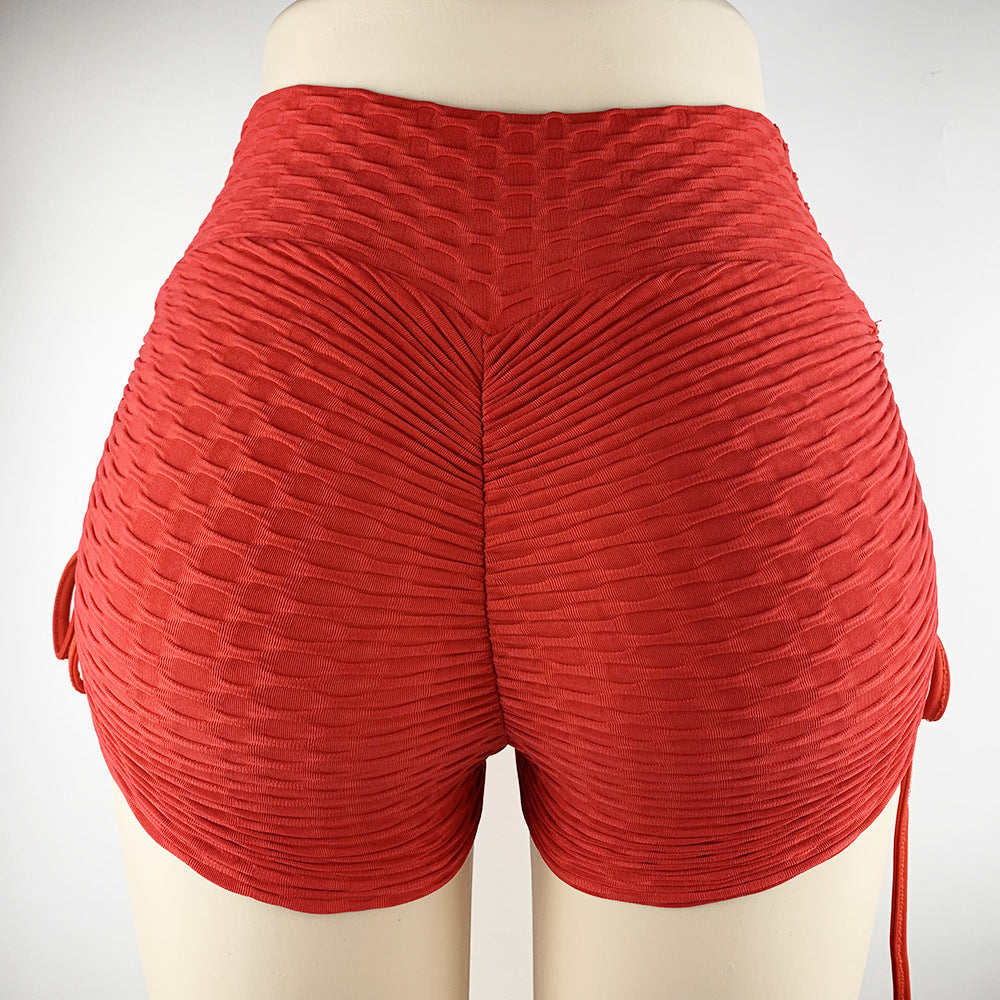 Red pleated shorts on a mannequin against a white background