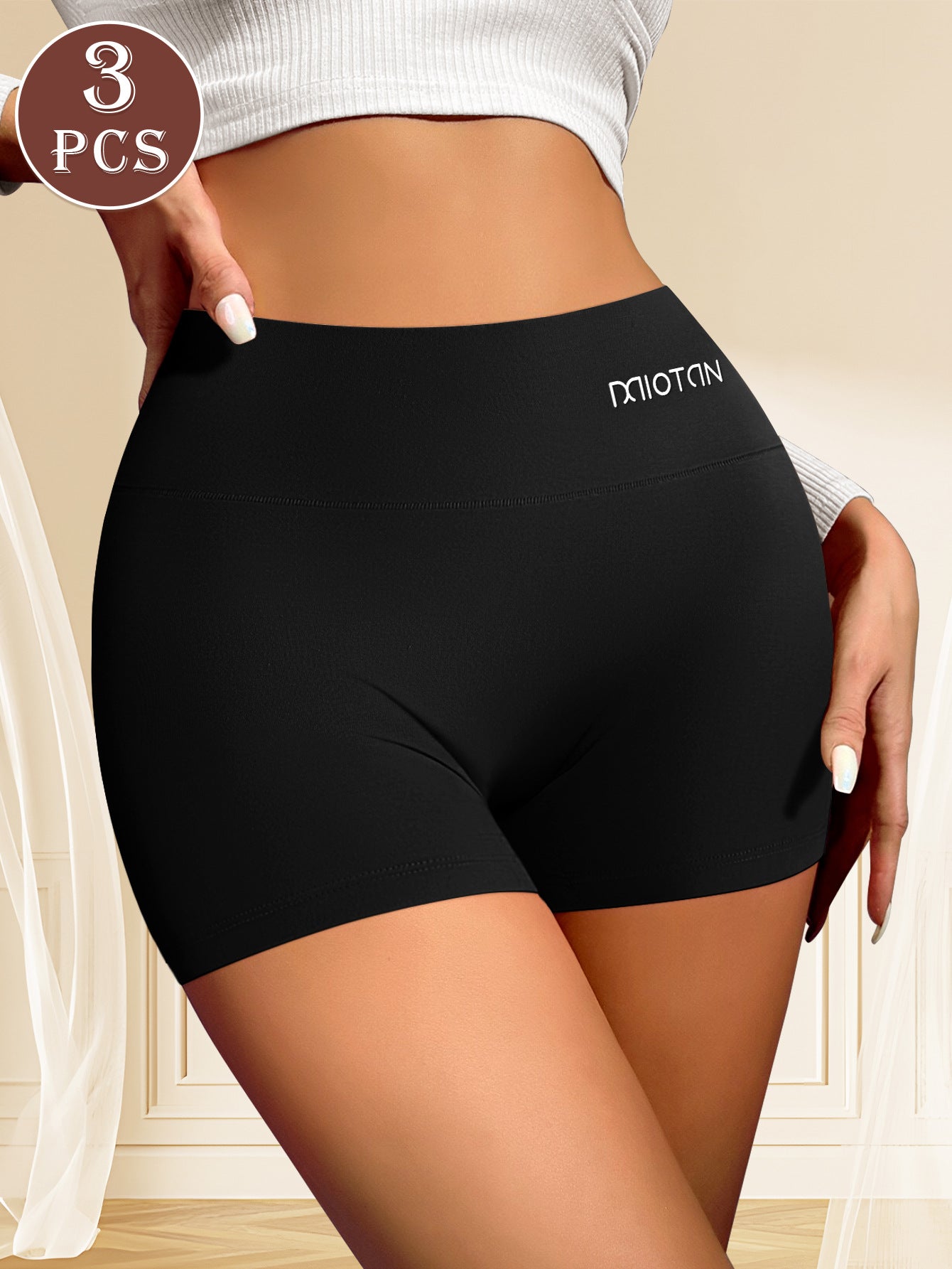 Black high-waisted shorts with a brand logo, shown on a person against a neutral background.
