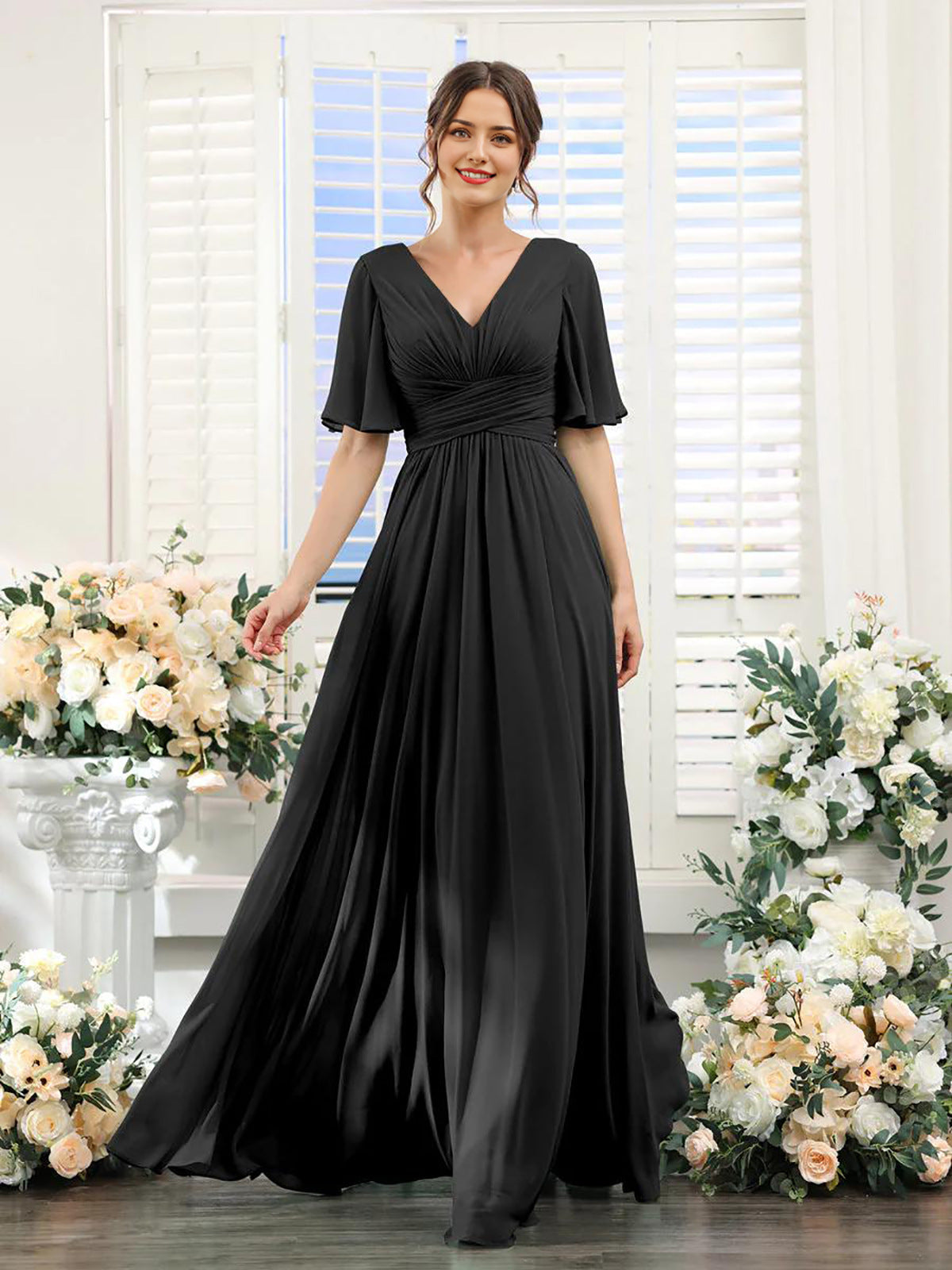 Woman wearing a black dress standing in front of floral decorations